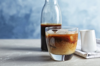 Glass with cold brew coffee and milk on table