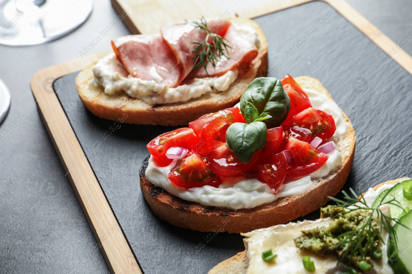 Photo of Board with different tasty bruschettas on table, closeup