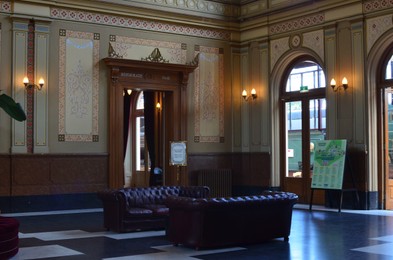 Photo of Utrecht, Netherlands - July 23, 2022: Spoorwegmuseum. Hall with luxurious leather sofas and wooden doors