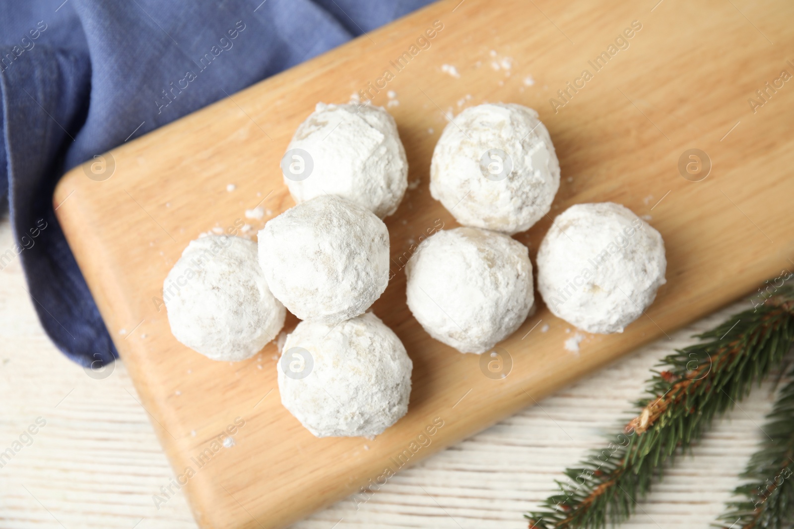 Photo of Christmas snowball cookies on light wooden table, flat lay