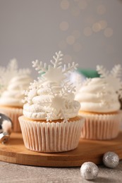 Photo of Tasty Christmas cupcakes with snowflakes on grey table