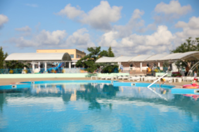 Blurred view of outdoor swimming pool with clear water on sunny day. Summer vacation