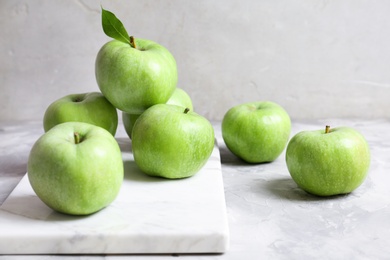 Photo of Marble board with fresh green apples on table