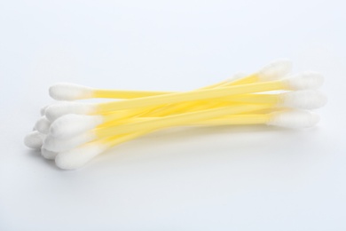 Photo of Yellow plastic cotton swabs on white background