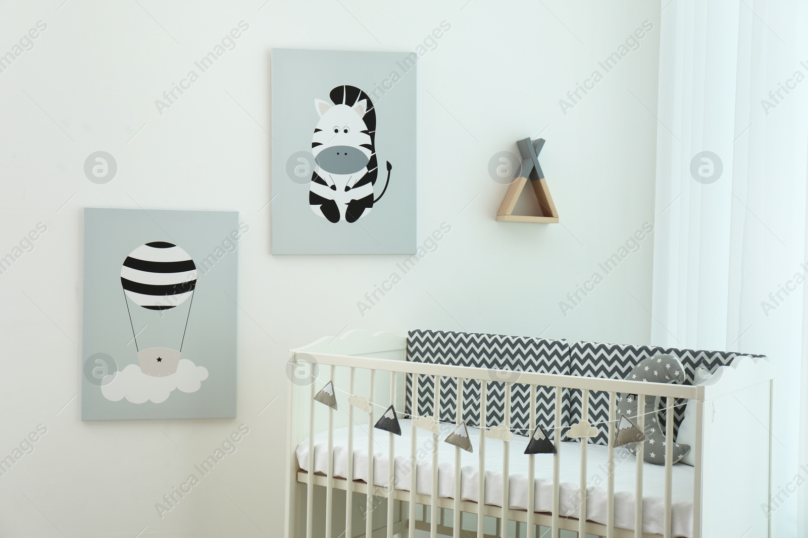 Photo of Stylish baby room interior with crib and cute wall art