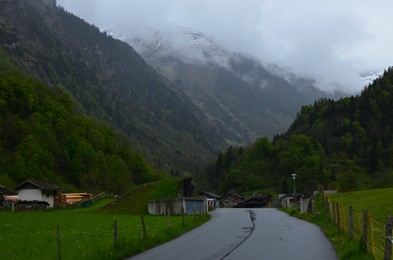 Photo of View of empty asphalt road and buildings in mountains