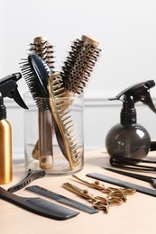 Photo of Hairdresser tools. Different scissors and combs on wooden table in salon