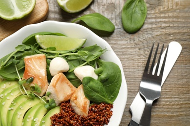 Photo of Delicious avocado salad with chicken on wooden table, flat lay