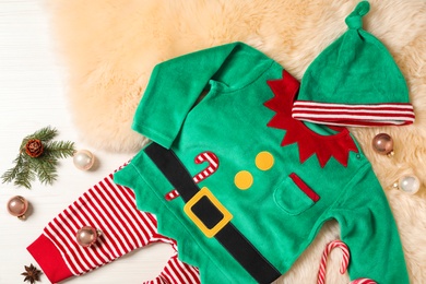 Photo of Flat lay composition with cute Christmas baby clothes on white wooden background