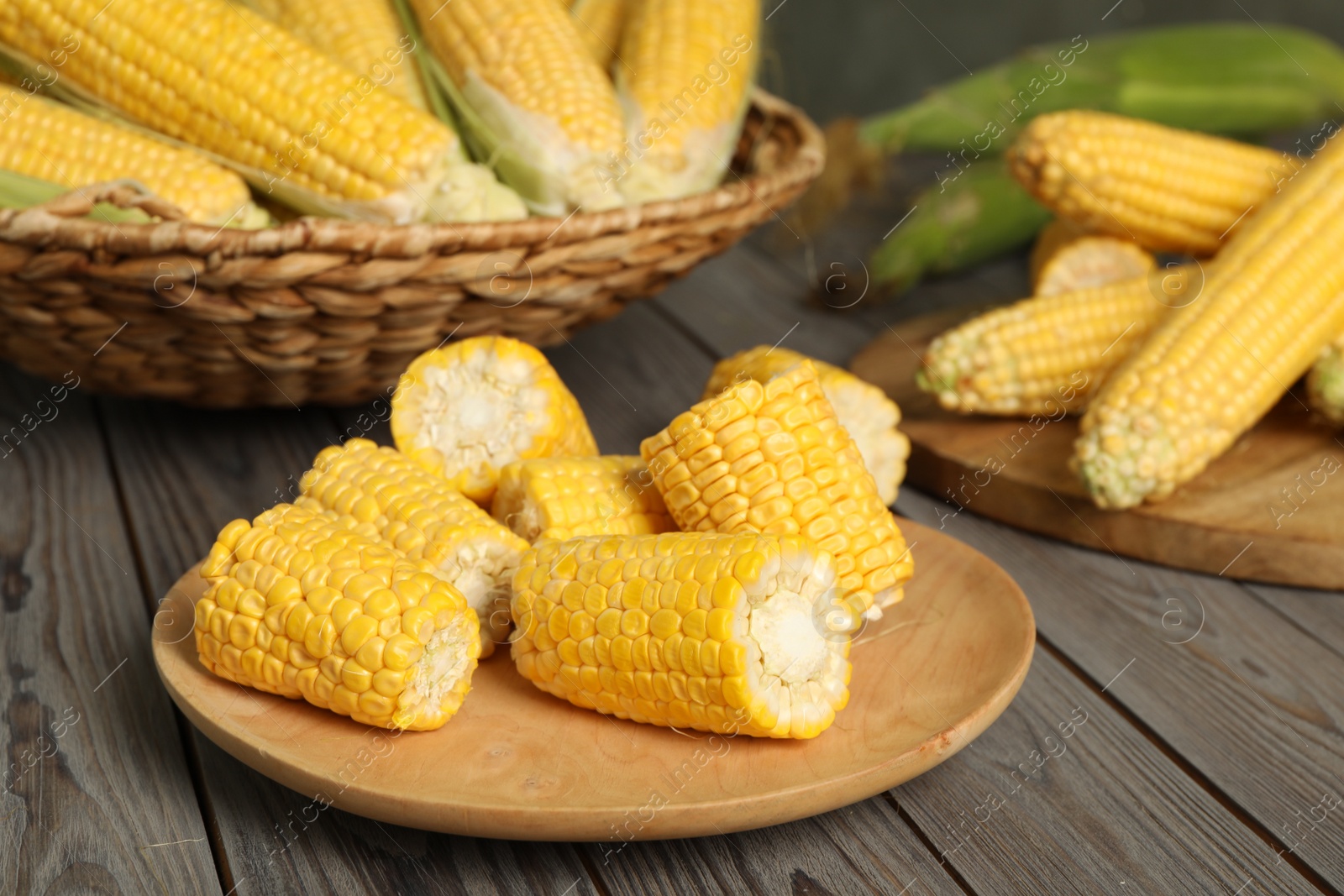 Photo of Tasty sweet corn cobs on wooden table, closeup