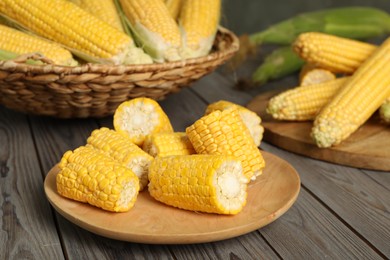 Photo of Tasty sweet corn cobs on wooden table, closeup