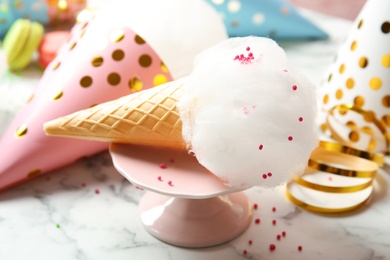 Photo of Ice cream cone with cotton candy served on table