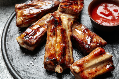 Photo of Delicious grilled ribs on board, closeup view