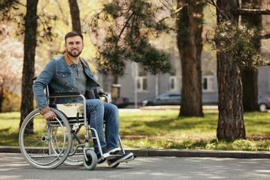 Young man in wheelchair at park on spring day