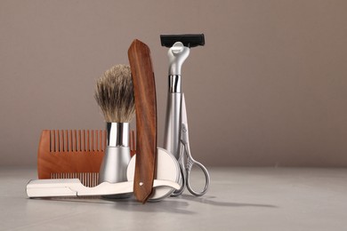 Photo of Moustache and beard styling tools on grey table. Space for text