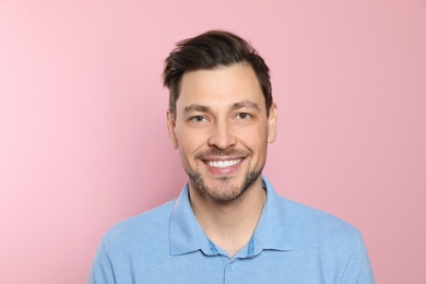 Photo of Smiling man with perfect teeth on color background