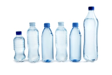 Photo of Row of different plastic bottles with water on white background