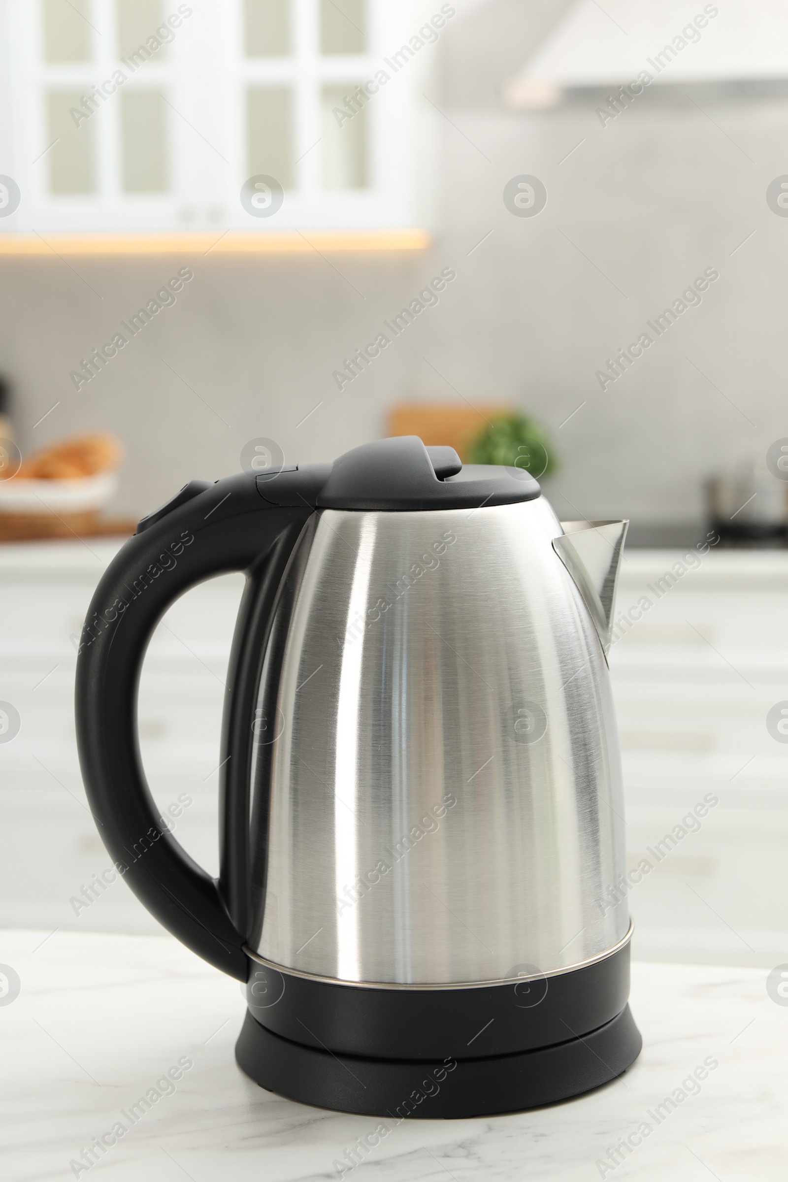 Photo of Modern electric kettle on table in kitchen