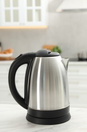 Modern electric kettle on table in kitchen