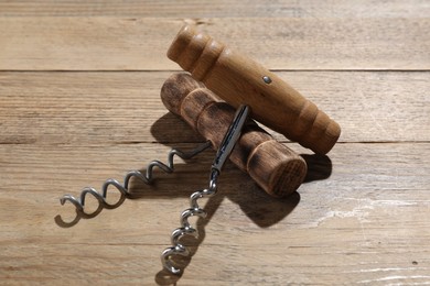 Photo of Two different corkscrews on wooden table. Kitchen utensil