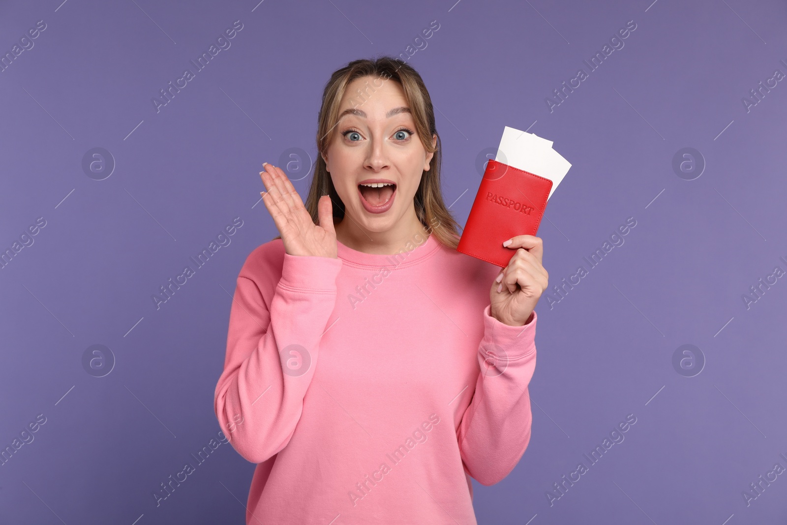 Photo of Emotional young woman with passport and ticket on purple background
