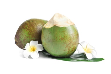 Photo of Fresh green coconuts with flowers on white background