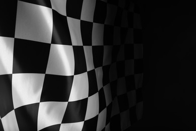 Photo of Checkered flag on black background, space for text