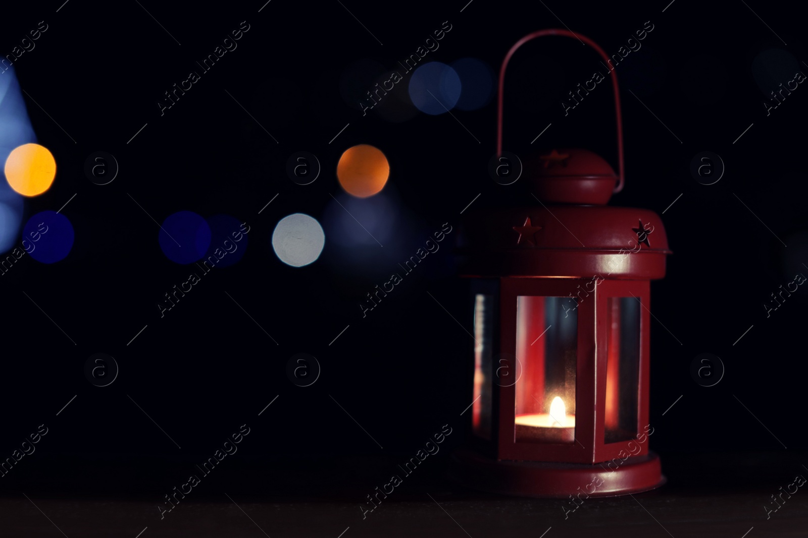 Photo of Lantern on wooden railing outdoors against blurred background, space for text. Winter night