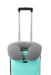 Photo of Soft travel pillow on turquoise suitcase isolated on white