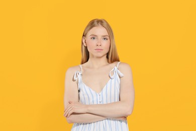 Photo of Beautiful young woman posing on orange background