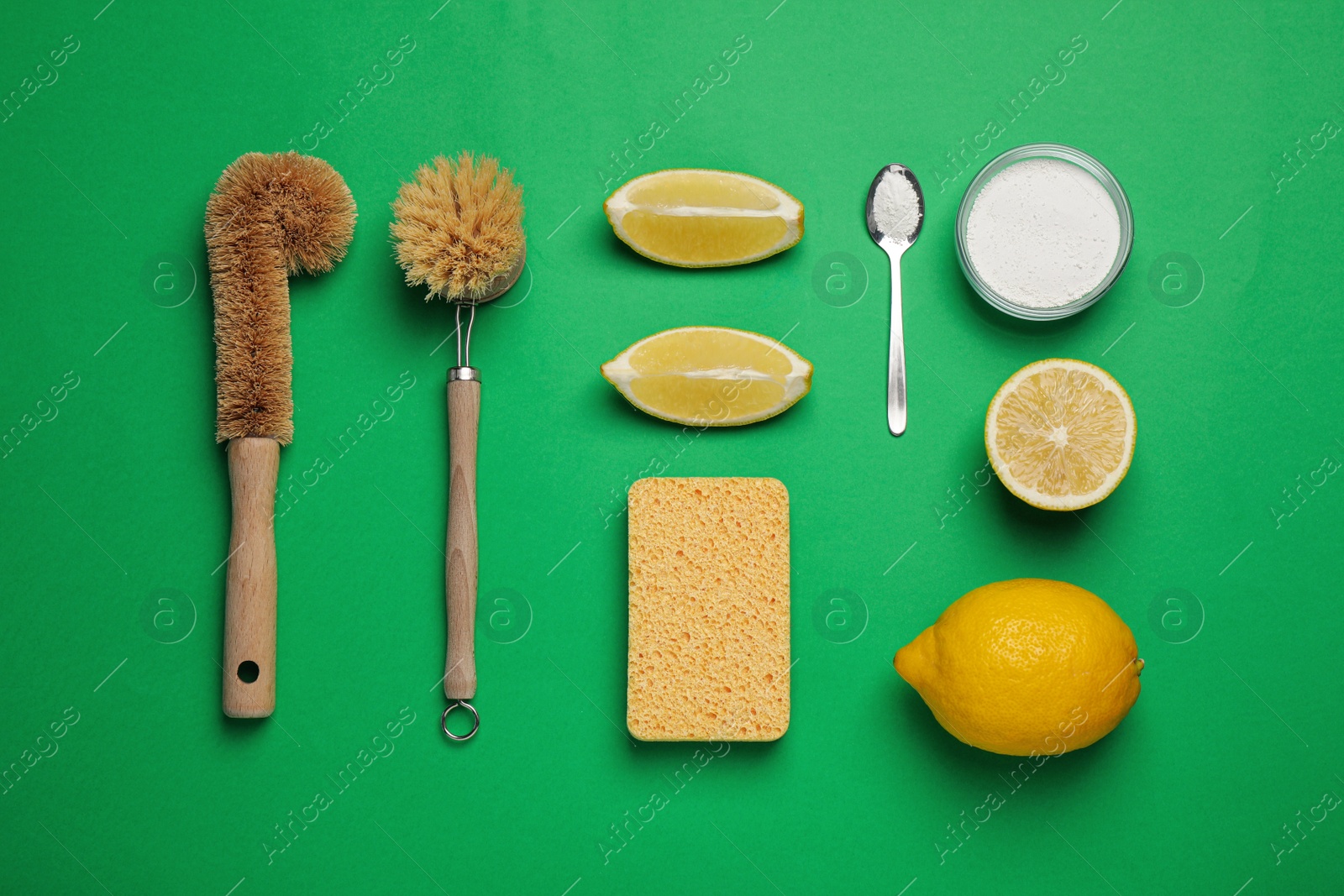 Photo of Cleaning supplies for washing dishes on green background, flat lay