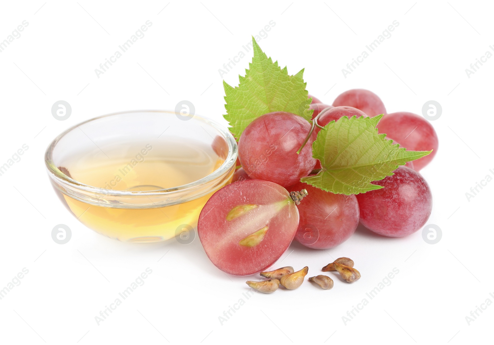 Photo of Organic red grapes, seeds and bowl of natural essential oil on white background