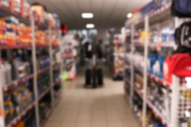 Blurred view of tires and car care products in auto store