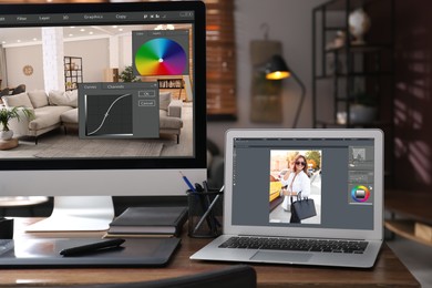 Photo of Retoucher's workplace. Computer and laptop with photo editor applications, graphic tablet on table indoors