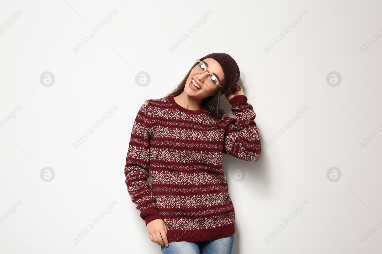 Photo of Young woman in warm sweater and hat on white background. Celebrating Christmas