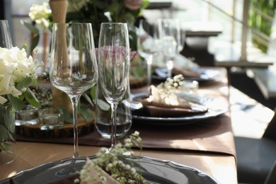 Photo of Festive table setting with beautiful tableware and floral decor in restaurant