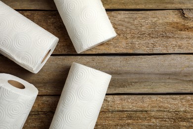 Photo of Rolls of white paper towels on wooden table, flat lay. Space for text