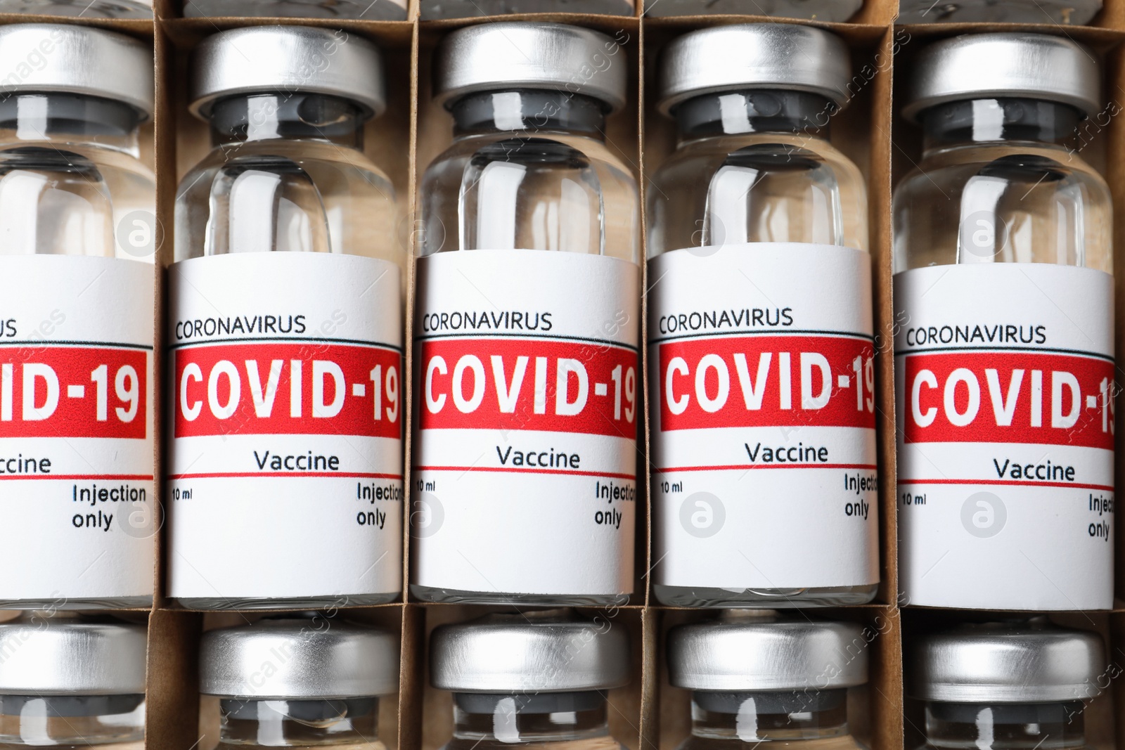 Photo of Glass vials with COVID-19 vaccine in package, top view