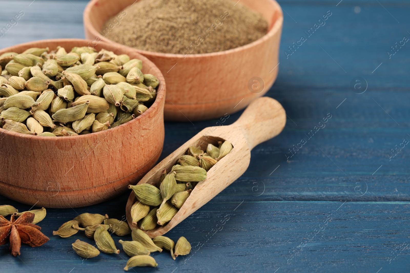 Photo of Cardamom and other spices on blue wooden table. Space for text