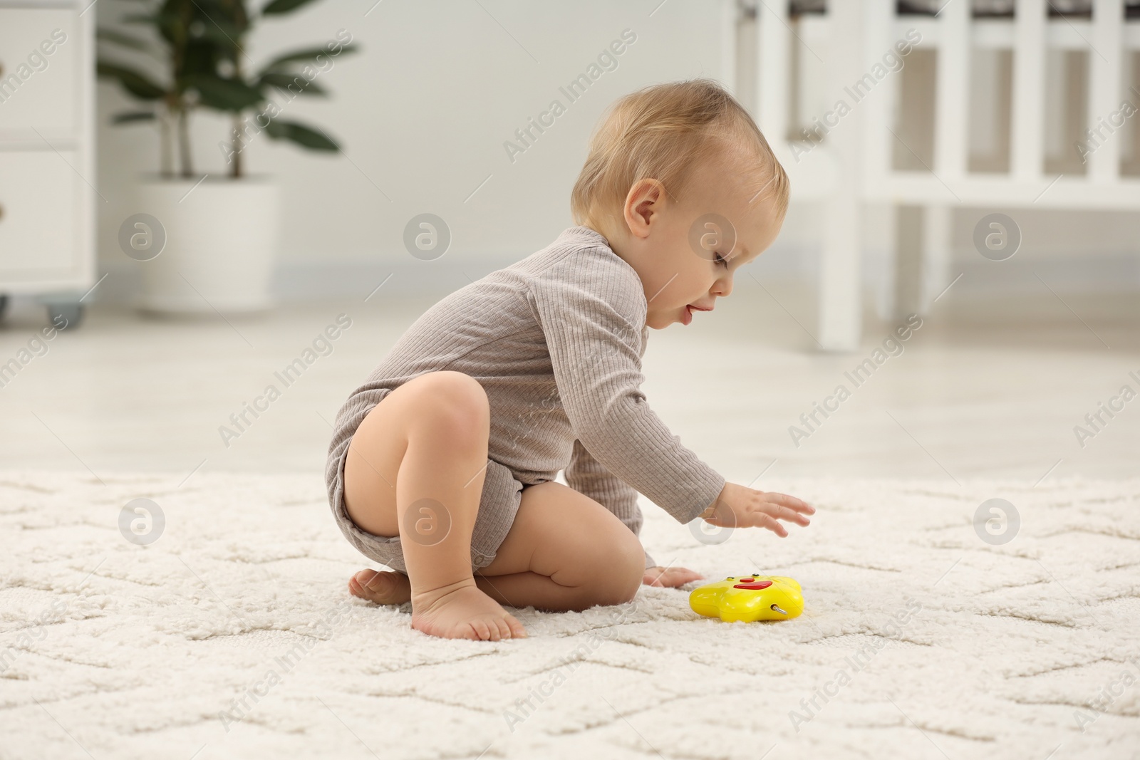 Photo of Children toys. Cute little boy playing with colorful toy on rug at home