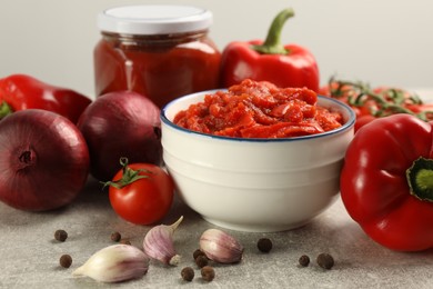 Photo of Delicious lecho and fresh ingredients on light grey table, closeup