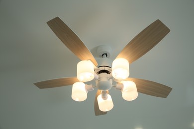 Ceiling fan with lamps indoors, low angle view