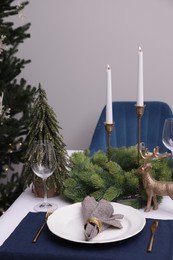Festive place setting with beautiful dishware, cutlery and fabric napkin for Christmas dinner on white table