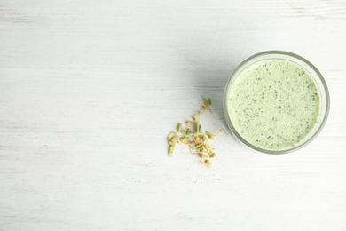 Green buckwheat smoothie on white wooden table, flat lay. Space for text