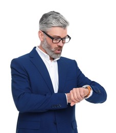 Mature businessman in stylish clothes checking time on white background