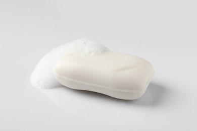 Soap with fluffy foam on white background
