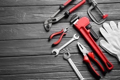 Flat lay composition with plumber's tools and space for text on wooden background