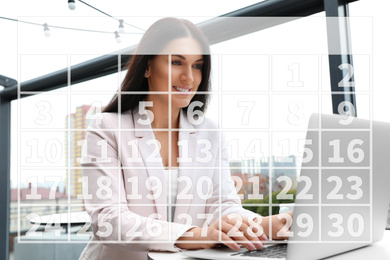 Image of Calendar and woman working with laptop in outdoor cafe