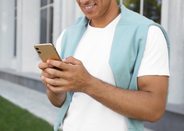 Man using modern mobile phone outdoors, closeup