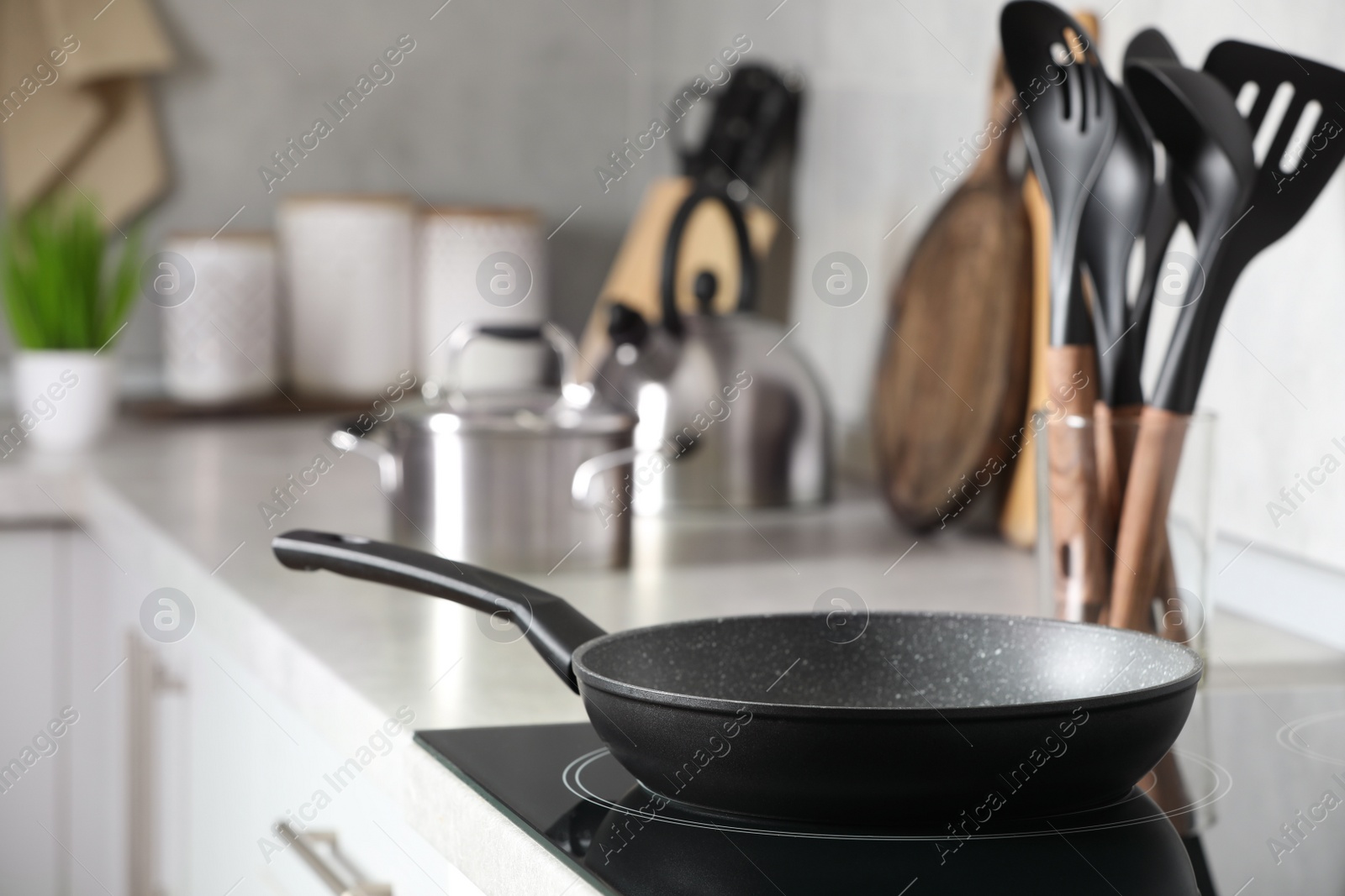 Photo of Frying pan and cooking utensils in kitchen, space for text